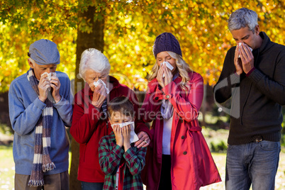 Sick family blowing their noses at park