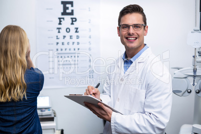 Optometrist writing on clipboard