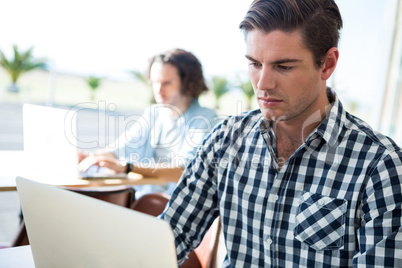 Man using laptop in coffee shop