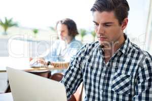 Man using laptop in coffee shop