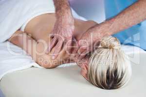 Woman receiving shoulder massage from physiotherapist
