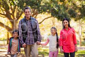 Portrait of family holding hands at park