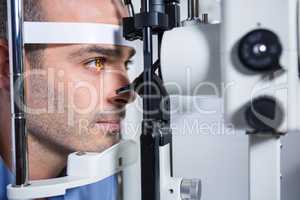 Male patient getting his cornea checked with slit lamp