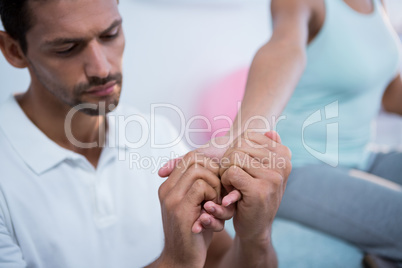 Physiotherapist giving hand massage to a woman