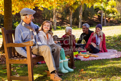 Family picnicking and the grandfather laughing with his grand da