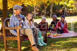 Family picnicking and the grandfather laughing with his grand da