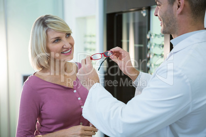 Optometrist consulting a customer about spectacles and frames