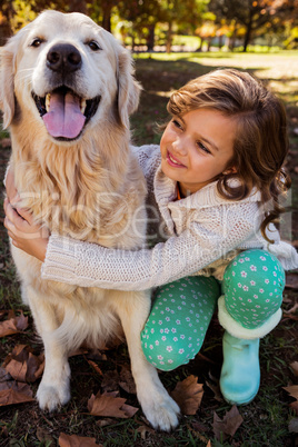 Portrait of little girl embracing her dog