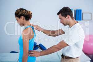 Physiotherapist examining womans back