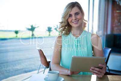 Portrait of woman using a digital tablet in the coffee shop