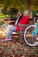 Mature couple relaxing on bench at park