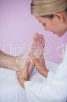 Physiotherapist giving foot massage to a patient