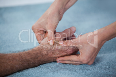 Physiotherapist giving hand massage to a patient