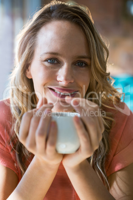 Portrait of smiling woman holding a coffee cup