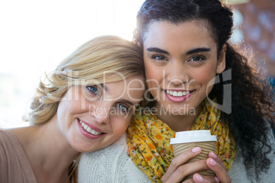 Portrait of female friends sitting together and having coffee