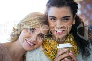 Portrait of female friends sitting together and having coffee