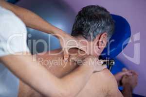 Physiotherapist giving back massage to a patient