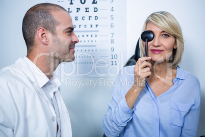 Optometrist examining female patient with medical equipment