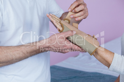 Mid section of physiotherapist examining a senior womans wrist