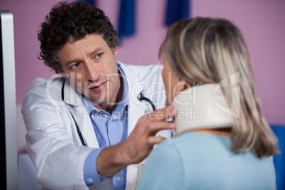 Physiotherapist examining a female patients neck