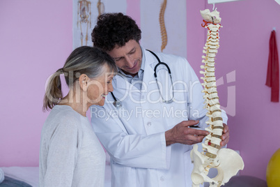 Physiotherapist explaining the spine model to patient