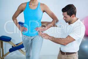 Physiotherapist examining womans back