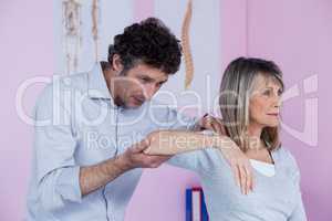 Physiotherapist giving shoulder massage to patient