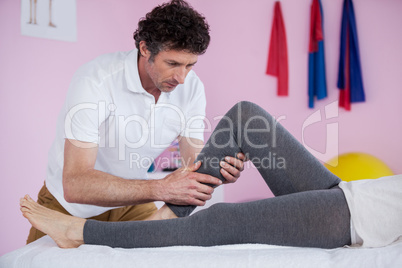 Physiotherapist giving leg massage to a senior woman