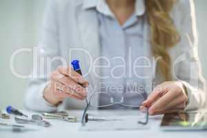 Female optometrist preparing glass frame