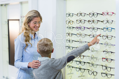Mother and son selecting spectacles from display