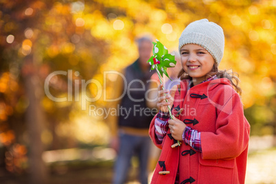 Cheerful girl with pinwheel toy at park