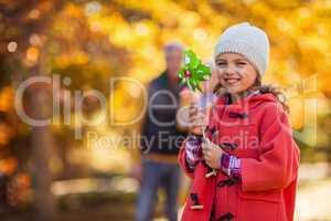 Cheerful girl with pinwheel toy at park
