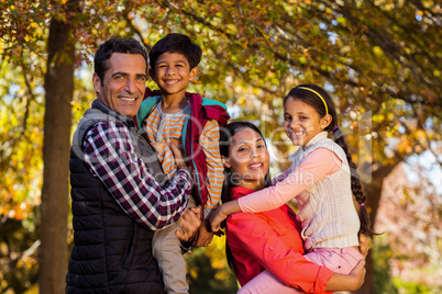 Parents carrying children while standing at park