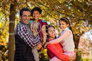 Parents carrying children while standing at park