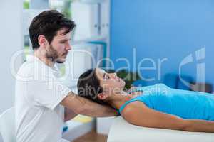 Male physiotherapist giving head massage to female patient