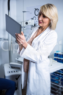 Optometrist using digital tablet in ophthalmology clinic