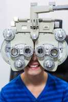 Young patient looking through phoropter during eye examination