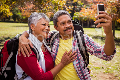 An elderly couple walking taking a selfie