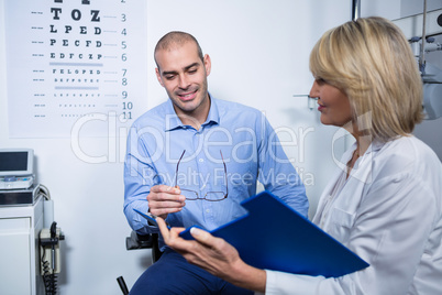 Female optometrist talking to male patient