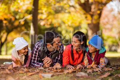 Happy family lying on field at park