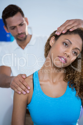 Physiotherapist giving neck massage to female patient