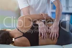 Male physiotherapist giving back massage to female patient