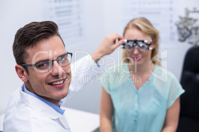 Optometrist examining female patient with phoropter