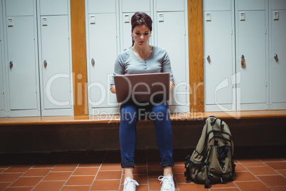 Mature student using laptop in the locker room