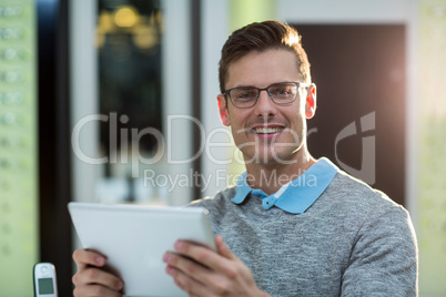 Smiling customer using digital tablet in optical store