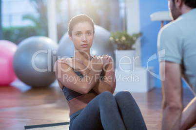 Physiotherapist assisting a female patient while exercising Physiotherapist assisting a female patient while exercising