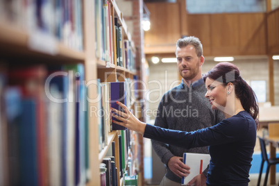 Mature student removing book from shelf