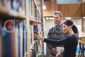 Mature student removing book from shelf