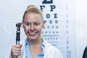 Female optometrist holding ophthalmoscope