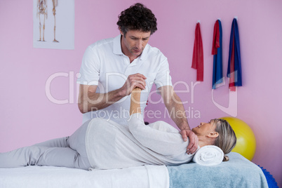 Physiotherapist massaging a senior womans shoulder